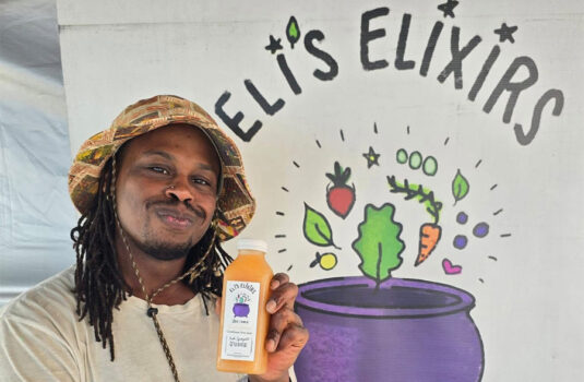 Owner Eli holds up a bottle of his juice.