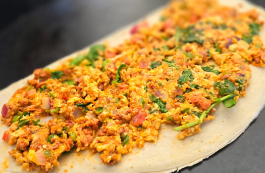 Close up of and open crepe filled with savory toppings